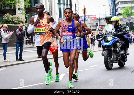 Londra, Regno Unito. Il 28 aprile 2019. Il vincitore della Vergine denaro London Marathon Uomini Elite di gara, Eliud Kipchoge (KEN) (L), Mosinet Geremew (ETH) (C) e Tola Shura Kitata (ETH) (R) passano attraverso il miglio 23. La gara è stata vinta da Eliud Kipchoge (KEN) in un nuovo corso tempo record di 2:02:37. Credito: Stephen Chung / Alamy Live News Foto Stock