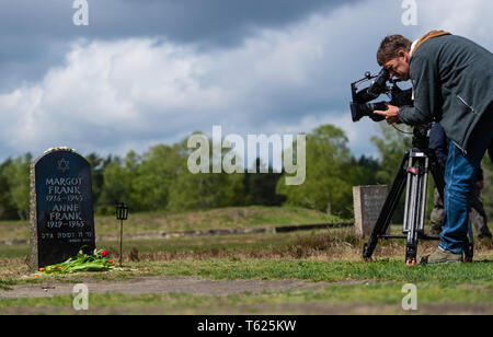 Lohheide, Germania. 28 apr, 2019. Un cameraman film la lapide per Margot e Anne Frank sul sito dell'ex campo di concentramento. Più di 52.000 campo di concentramento i prigionieri e 20.000 prigionieri di guerra morì nel Bergen-Belsen camp nella brughiera di Lüneburg. Soldati britannici liberati i superstiti 74 anni fa. Credito: Philipp Schulze/dpa/Alamy Live News Foto Stock