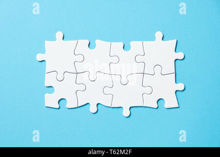 Otto pezzi white jigsaw puzzle su sfondo blu per presentazioni aziendali Foto Stock