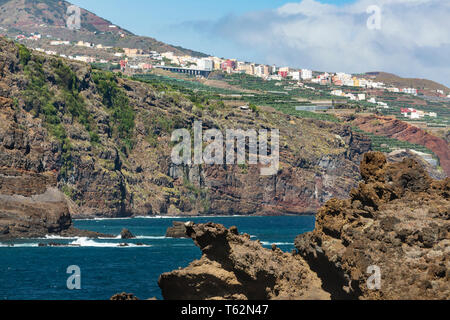 Cliff costa vicino a Playa de Nogales beach a La Palma, Spagna con vista del villaggio di Los salse. Foto Stock