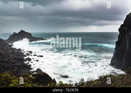 La tempesta e la pioggia con onde alte di colpire le rocce a Playa de Nogales beach a La Palma, Spagna. Foto Stock