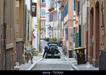 Auto della Polizia con due ufficiali di pattuglia nella strada laterale del centro storico di Heidelberg in Germania Foto Stock