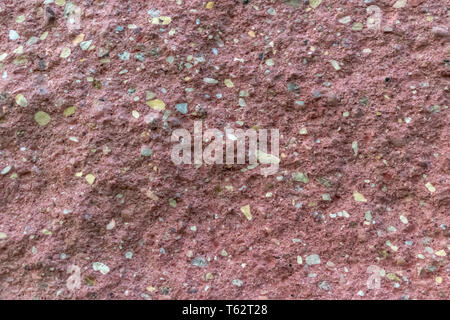Texture di sfondo di una pietra rossa versata in un monolito di calcestruzzo Foto Stock