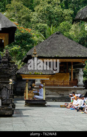 Leader di preghiera in una piccola cabina , Pura Tirta Empul temple, Ubud, Indonesia Foto Stock