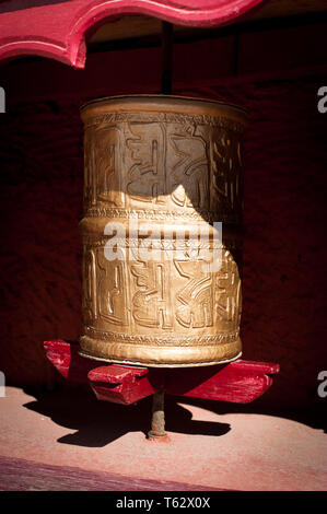 La preghiera buddista ruota decorati con simboli di sanscrito al monastero tibetano. Ornati in rotazione il cilindro tradizionale con il testo del Mantra scritti su di esso per Foto Stock