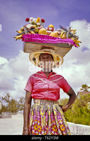 Anni sessanta Caraibi donna BARBADOS trasporto nativo cesto pieno di fresca frutta tropicale sulla sua testa - KR6568 LAN001 HARS ISOLE VENDITA afro-americani afro-americano a basso angolo di etnia nera occupazioni cappello di paglia BARBADOS Lesser Antilles frutti MID-adulto metà donna adulta in vecchio stile afro-americani Foto Stock