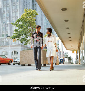 Anni Settanta americano africano giovane Holding Hands parlando a piedi lungo una strada di città guardando OGNI ALTRA - ks12636 MER001 HARS STILE EQUILIBRIO COMUNICAZIONE TEAMWORK LIETA GIOIA LIFESTYLE femmine coniuge sposato mariti spazio copia amicizia a tutta lunghezza LADIES PERSONE CARING PARTNER maschi felicità allegro avventura stili di svago afro-America orgoglio sorriso gioioso concettuale ELEGANTE IN OGNI ALTRA MODE MID-adulto metà uomo adulto a metà donna adulta relax convivere mogli di vecchio stile Foto Stock
