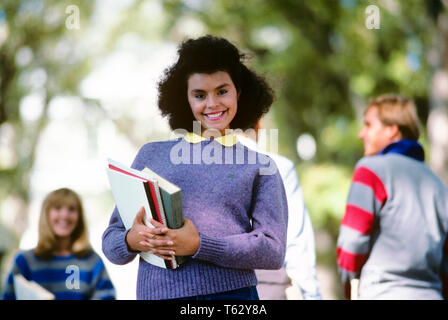 Anni ottanta giovani African American college femminile STUDENTE IL TRASPORTO DI LIBRI guardando la fotocamera - ks24466 DEG002 colore HARS vecchio tempo NOSTALGIA OLD FASHION 1 stile giovanile giovane adulto lieta gioia LIFESTYLE CAMPUS femmine salubrità spazio copia di metà lunghezza figlie razza ragazza adolescente contatto degli occhi viola la felicità allegro università afro-americani afro-americano nero conoscenza etnia sorrisi femminile ISTRUZIONE SUPERIORE GIOIOSA LONE elegante collegi adolescente COED crescita superiore novellame giovane uomo adulto giovane donna adulta in vecchio stile afro-americani Foto Stock