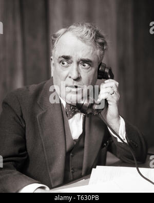 1930s business man in ascolto sul telefono con allarmato sconvolto preoccupato l'espressione del viso - t3549 HAR001 HARS NOSTALGIA OLD FASHION 1 trattamento viso rabbia shock di comunicazione scioccato PROBLEMA ERRORE LIFESTYLE ELDER lavori di copia di Manager spazio a mezza lunghezza persone premurose maschi rischio uomo senior executives adulti senior B&W tristezza professione vendere OLDSTERS politico antica storditi preoccupazione occupazioni politica telefoni anziani borchie telefoni ATTORNEY focalizzato i responsabili di intenso dei venditori in bianco e nero di etnia caucasica HAR001 intenti di vecchio stile Foto Stock