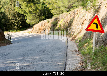 Segnale di avvertimento per il pericoloso girare a sinistra in montagna Foto Stock
