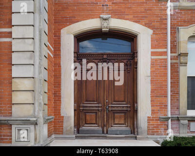 Vecchio scolpita in legno a doppio sportello anteriore di una grande casa Foto Stock