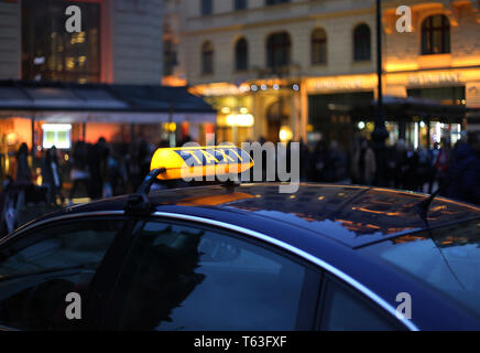 Primo piano della città Taxi segno di notte Foto Stock