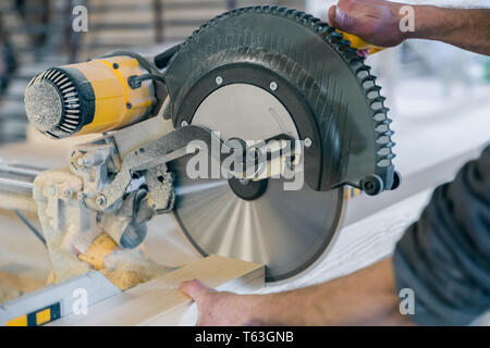 Operatore taglia una trave di legno sega circolare. Moderne attrezzature. Foto Stock