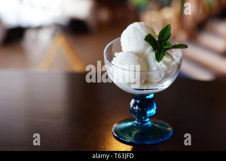 Palle di gelati in un bel bicchiere con un rametto di menta in un ristorante Foto Stock