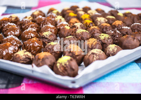 Gruppo di dolce e gustoso cioccolato artigianale palle su una carta di supporto cosparso con diversi sapori di spezie close up Foto Stock