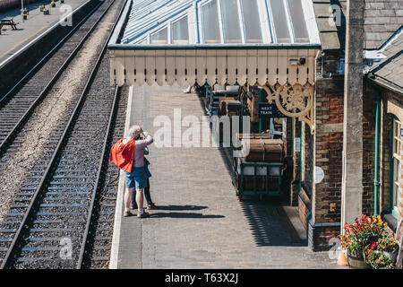 Sheringham, Regno Unito - 21 Aprile 2019: vista dal di sopra della gente che cammina su un treno retrò piattaforma di Sheringham stazione ferroviaria. Sheringham è un mare in inglese Foto Stock
