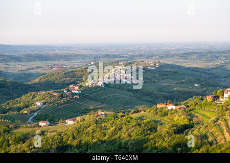 Piccolo villaggio Kozana su sunrise tra i vigneti in produzione vinicola della regione Brda in Slovenia vicino alla frontiera con l'Italia in Europa Foto Stock