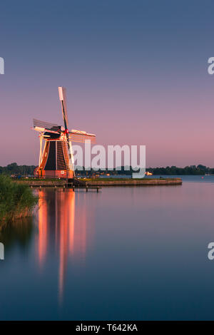 Mulino a vento De Helper a Paterswoldsemeer appena dopo il tramonto, vicino a Haren nella provincia di Groningen, Paesi Bassi Foto Stock