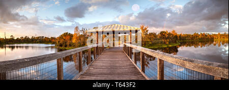 Ore del sorgere al tramonto su gazebo in legno appartato e tranquillo lungomare lungo una palude stagno nel Parco Freedom in Naples, Florida Foto Stock