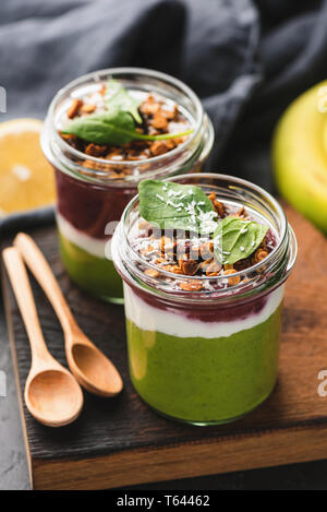 Avocado e Acai berry smoothie strato rabboccato con crunchy granola. Vegano sano, cibo vegetariano. Detox concept Foto Stock