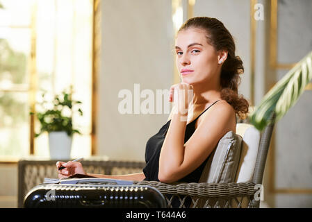 Attraente giovane donna nella hall hotel Foto Stock