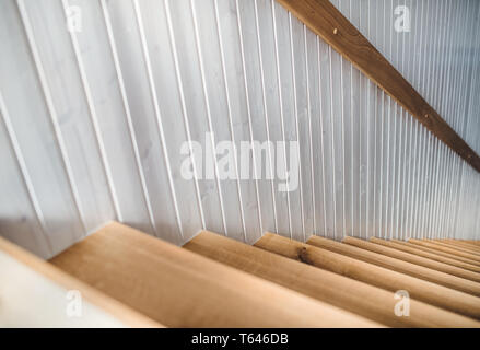 Scala di legno e legno bianco parete di bordo in un interno se una casa. Copia dello spazio. Foto Stock