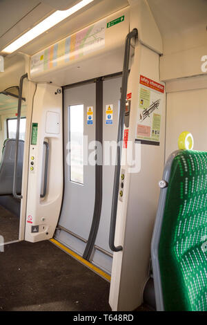 Primo piano delle porte dei treni, chiuse, prese all'interno di una moderna carrozza ferroviaria britannica. Trasporto ferroviario del Regno Unito. Foto Stock