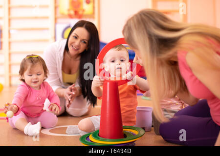 Vivaio gruppo bambini divertendosi in asilo nido palestra Foto Stock