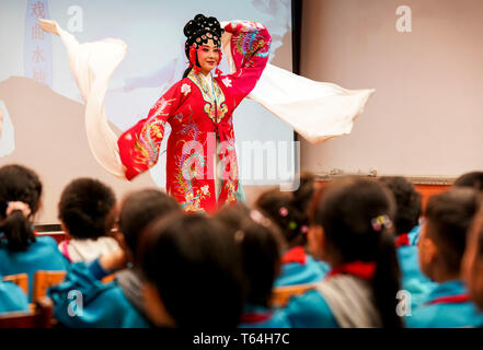 (190429) -- URUMQI, Aprile 29, 2019 (Xinhua) -- attrice egli Nina esegue in una scuola primaria in Urumqi, capitale del nord-ovest della Cina di Xinjiang Uygur Regione autonoma, 25 aprile 2019. Nato in una famiglia dedicata all opera Qinqiang, un folk cinese opera nel nord ovest della Cina, 33-anno-vecchio attrice Nina ha svolto il ruolo di una giovane donna in opera in corrispondenza di un opera Qinqiang troupe in Urumqi dal 2005. Al di là di teatri, egli Nina e i suoi colleghi hanno eseguito l'opera nelle comunità e nelle scuole per promuovere il cinese tradizionale opera di cultura. Esecuzione di opere classiche di opera Qinqiang dovrebbero essere adattate alla moderna Foto Stock