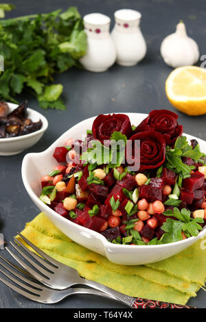 Lean ceci e insalata di barbabietole decorate con barbabietola Rose in un bianco insalatiera su sfondo scuro Foto Stock