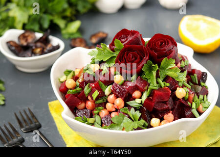 Lean ceci e insalata di barbabietole decorate con barbabietola Rose in un bianco insalatiera su sfondo scuro Foto Stock