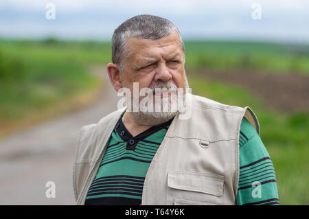 Nice outdoor ritratto del Caucaso uomo senior con intenti guardare Foto Stock