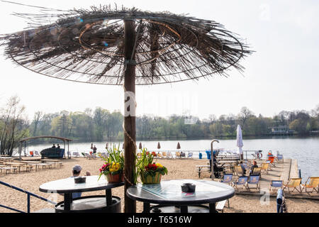 Berlino,Pankow. Weissensee Strandbad, Lago Bianco spiaggia con ombrelloni e sedie a sdraio. Wild Water Swimming sito. Foto Stock