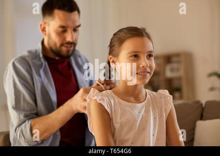 Padre figlia di intrecciatura capelli a casa Foto Stock