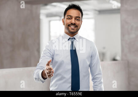 Commerciante indiano mano di stiramento per stretta di mano Foto Stock