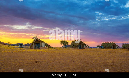 Sunrise sopra i piccoli chalets di una desert lodge vicino al Sossusvlei in Namibia Foto Stock