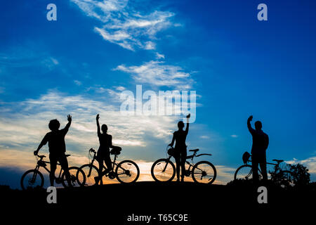 I ciclisti che ondeggia con le mani sul tramonto Cielo. Foto Stock