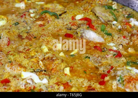 Chiudere la cucina tradizionale spagnola di Valencia la paella mista con carne di pollo, pesce e verdure in grande padella, ad alto angolo di visione Foto Stock