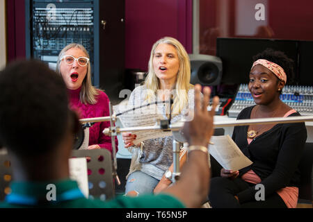 Womens coro con foglio di musica a cantare in music studio di registrazione Foto Stock