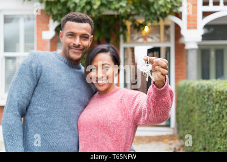 Ritratto coppia felice con le chiavi di casa fuori casa nuova Foto Stock