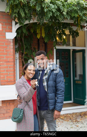 Ritratto fiducioso giovane con le chiavi di casa fuori casa nuova Foto Stock