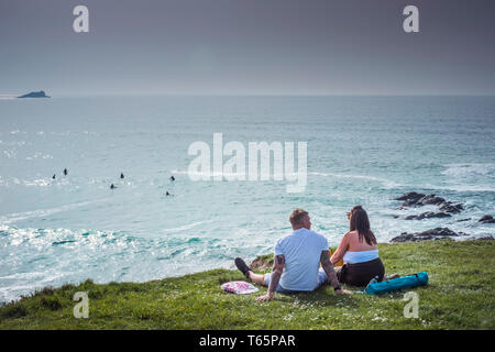 I villeggianti rilassante lungo la costa che si affaccia Fistral Bay a Newquay in Cornovaglia. Foto Stock