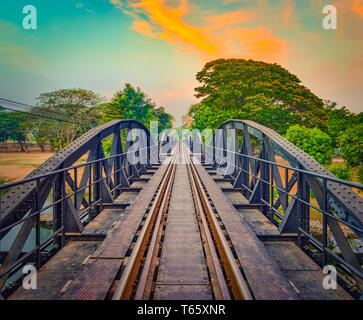 Il ponte sul fiume Kwai a sunrise. Bellissima vista della linea ferroviaria. Attrazione turistica di Kanchanaburi, Thailandia Foto Stock