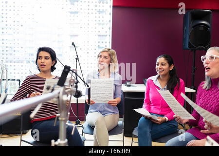 Womens coro con foglio di musica a cantare in music studio di registrazione Foto Stock