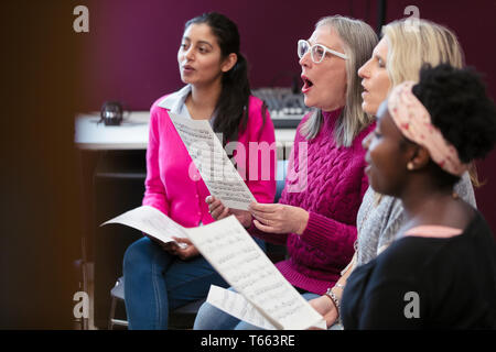 Womens coro con foglio di musica a cantare in music studio di registrazione Foto Stock