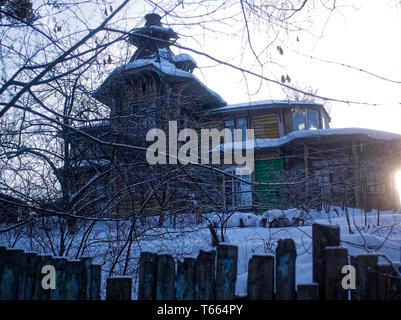 Vecchia casa in legno dietro il recinto in inverno, Russia Foto Stock