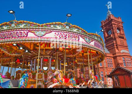 Fiera carosello ride e torre del grado 1 elencati Edificio Pierhead (Adeilad Pierhead y), la Baia di Cardiff, Galles, Regno Unito. Foto Stock