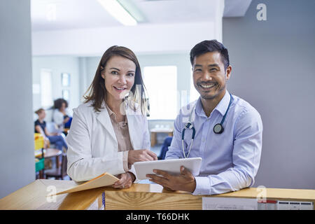 Ritratto fiducioso medici con tavoletta digitale in clinica Foto Stock