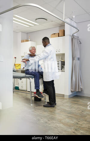 Maschio esame medico paziente senior in clinica sala esame Foto Stock
