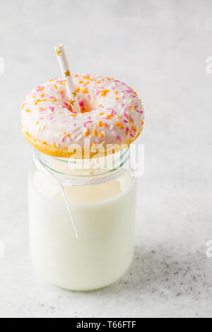 Latte in barattolo e rosa ciambella, spazio di copia Foto Stock